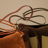 Close up on the strap of Suede Penelope Sr. bag in Brown with fold-over magnetic closure
