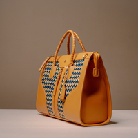 Angled View of Luxury Eva Sofia Bag with leather trim, natural fiber weave, and adjustable shoulder strap