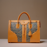 Front View of Luxury Eva Sofia Bag with leather trim, natural fiber weave, and adjustable shoulder strap