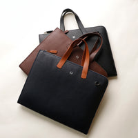 Black and brown leather bags on a light beige background