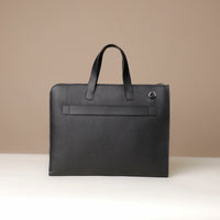 Black leather briefcase on a beige background