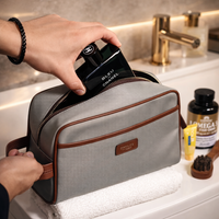 Person placing a Chanel product into a gray toiletry bag on a bathroom counter.