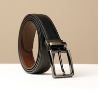 A black and brown dual use belt with a metallic buckle on a light background.