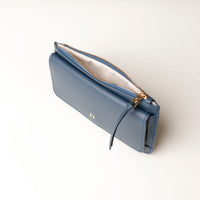 Blue wallet with gold zipper on a light background