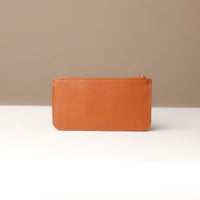 Tan leather pouch on a neutral background
