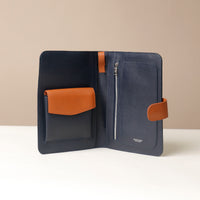 An open Globetrotters Document Holder navy blue with tan, with silver hardware, with compartments for documents
