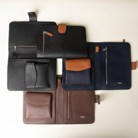 Collection of Globetrotters Document Holders in variety of colors, made with premium leather, on a beige background
