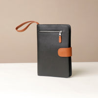 Globetrotters Document Holder black with brown pebble leather, with a brown leather strap, front view
