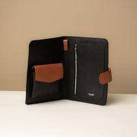 Open view of a Globetrotters Document Holder black and tan pebbled leather with gold hardware