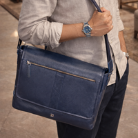 Person holding a navy blue leather bag with a blurred background