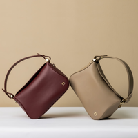 Two handbags, one red and one beige, on a light beige background