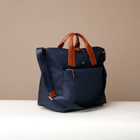 Navy blue bag with brown handles on a beige background