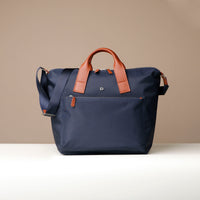Navy blue bag with brown handles on a beige background