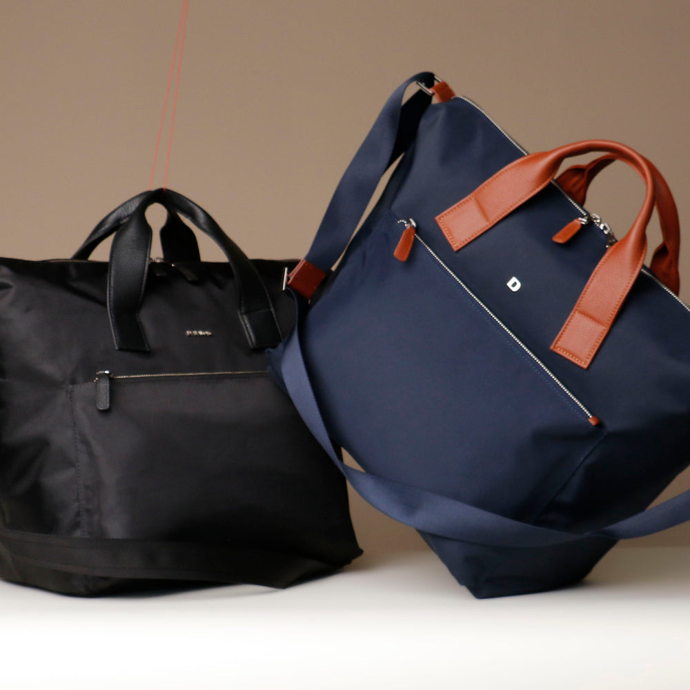 Black and blue bags with brown handles on a neutral background