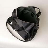 Black duffel bag with a visible brand logo on a light background