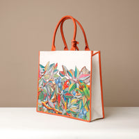Side view of orange Mercatto Tote Bag with double leather handles and woven detail