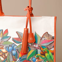 Close up view of orange Mercatto Tote Bag with double leather handles and woven detail