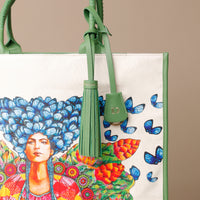 Close up view of green Mercatto Tote Bag with double leather handles and woven detail