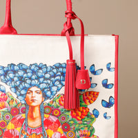 Close up view of red Mercatto Tote Bag with double leather handles and woven detail