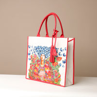 Side view of red Mercatto Tote Bag with double leather handles and woven detail