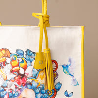 Close up view of yellow Mercatto Tote Bag with double leather handles and woven detail