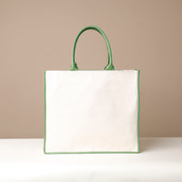 Back view of green Mercatto Tote Bag with double leather handles and woven detail
