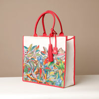 Side view of red Mercatto Tote Bag with double leather handles and woven detail
