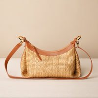 Mini Mia 26 Raffia tan handcrafted with raffia and premium leather, with gold hardware and a leather strap, in a beige background, front view
