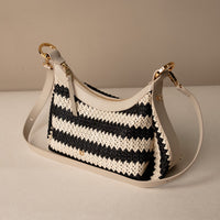 Mini Mia 26 Raffia Arena handcrafted with raffia and premium leather, with gold hardware and a leather strap, in a beige background, lateral view
