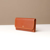 Brown leather wallet on a white surface with a beige background