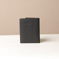 Black Back view of leather passport case Nirua on neutral background