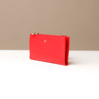 Red leather pouch with gold zipper on a neutral background