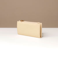 Beige wallet on a white surface with a beige background