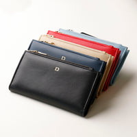 Stack of leather wallets in various colors on a white background