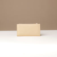 Beige pouch on a white surface with a beige background