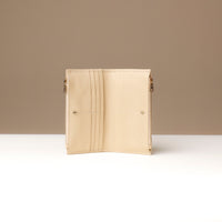 Beige wallet open on a white background with a beige wall.