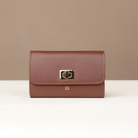 Brown leather wallet with a gold clasp on a beige background