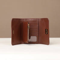 Brown leather wallet with gold zipper on a beige background