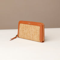 Woven wallet with brown leather trim on a white surface