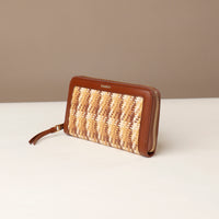 Woven wallet with brown leather accents on a beige background