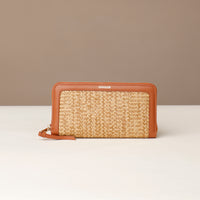 Woven wallet with brown leather accents on a beige background
