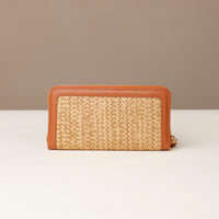 Woven wallet with brown leather trim on a neutral background