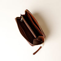 Brown leather wallet with a zipper on a white background