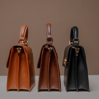 Three Nelda Bag elegant leather handbag with detachable shoulder strap in brown and black on a neutral background
