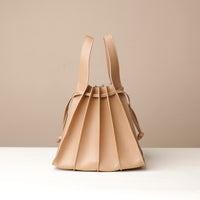Front view of beige Papillon Bag pleated leather bucket bag by Danilo’s