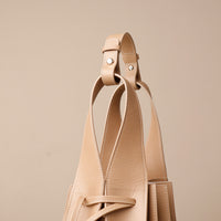 Close up view of beige Luxury leather bucket bag with multiple carry options