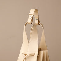 Close up view of white Luxury leather bucket bag with multiple carry options