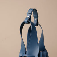Close up view of blue Luxury leather bucket bag with multiple carry options