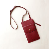 Red crossbody bag with a gold clasp on a white background