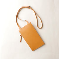 Tan leather crossbody bag on a white background